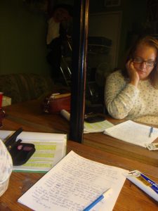 Julie JordanScott sitting backstage in a theater dressing room, catching up on writing while waiting during rehearsal. 