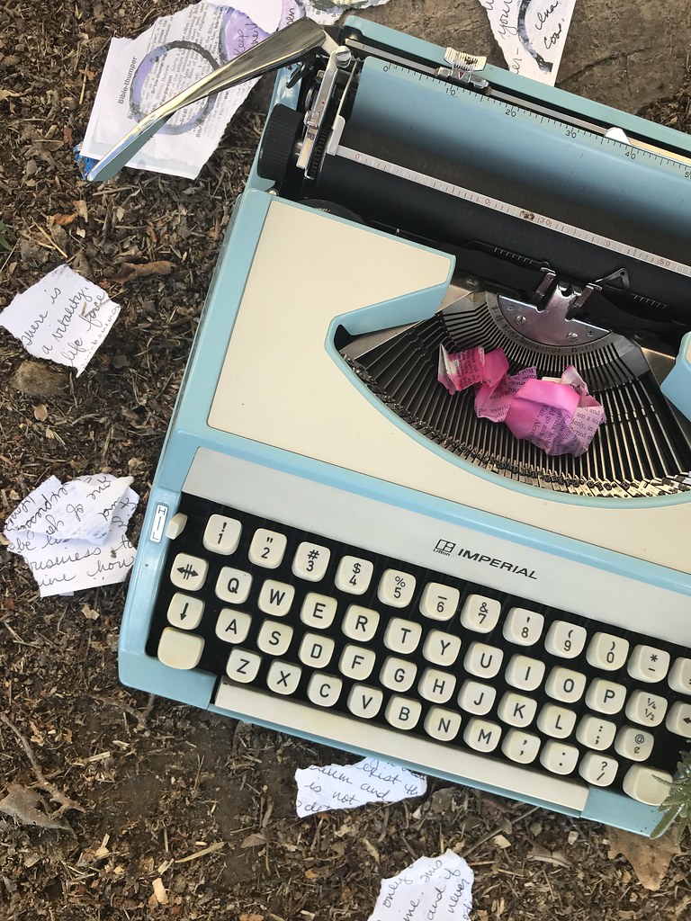 A 1970's era portable typewriter with paper torn around it on the ground to be a metaphor for the torn up promise of 2020.