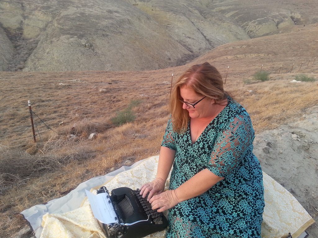 Julie JordanScott typing a love poem on the edge of a foothill of the Sierra Nevada Mountains.