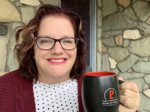 Julie Jordan Scott sits on her porch drinking coffee from a Lowell Observatory mug