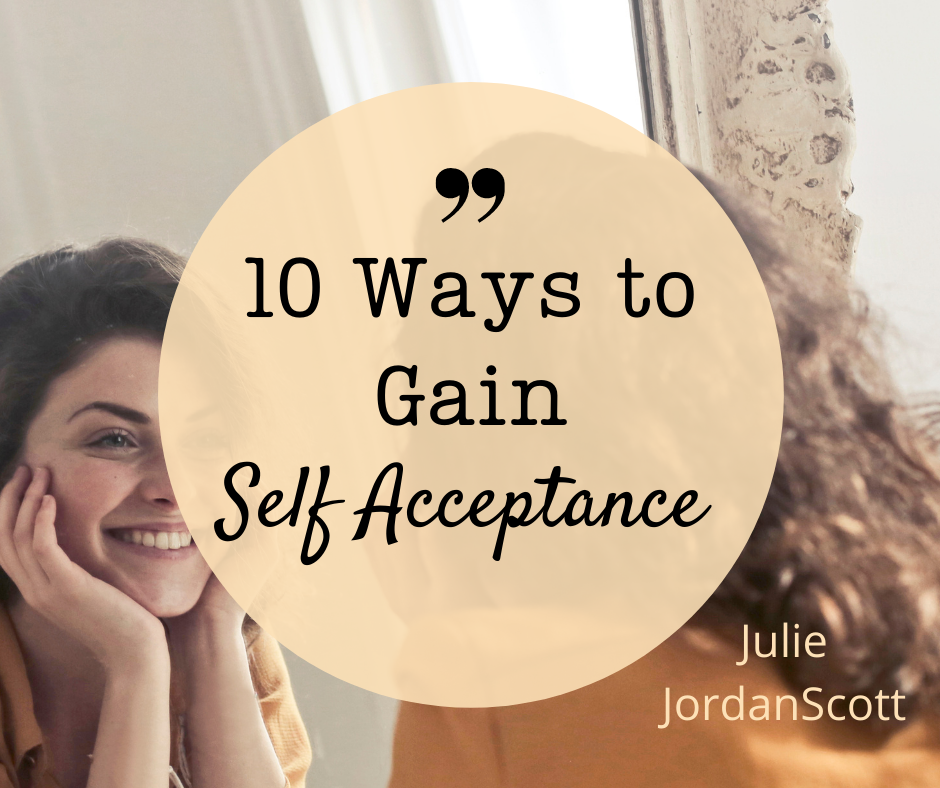 A woman looking in a mirror smiling at herself is a model of the article, 10 Ways to Gain Self Acceptance by Julie JordanScott