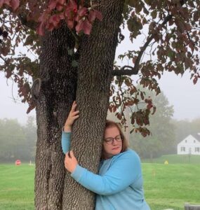 A woman hugging a dogwood tree, prayerfully, at Antietam, the Civil War Battlefield